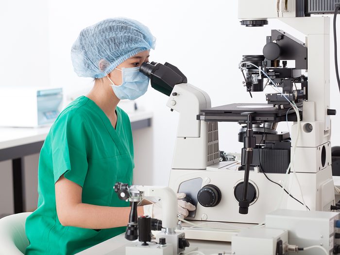 Medical researcher using microscope