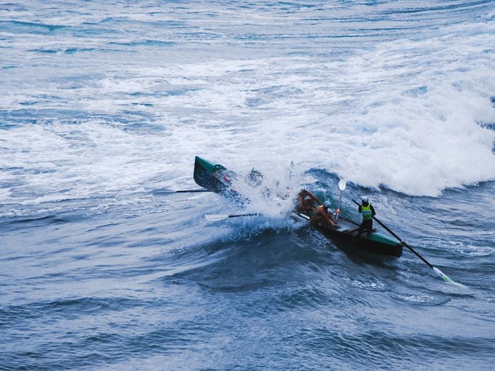 Rowing boat into crashing waves