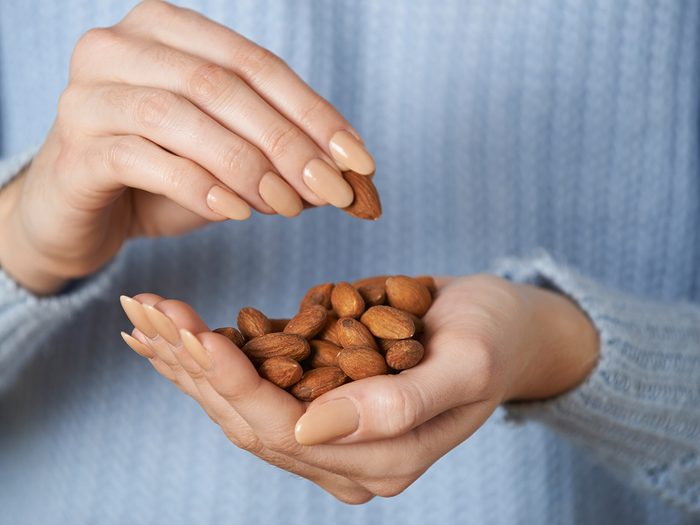 Best protein sources - woman holding almonds in hand
