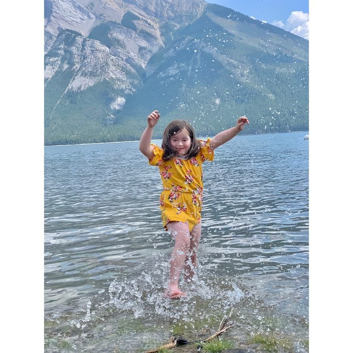 Candid photography - little girl splashing in mountain lake