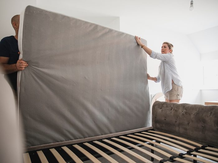 Flip your mattress - Mature couple are setting up their bed in their new home.