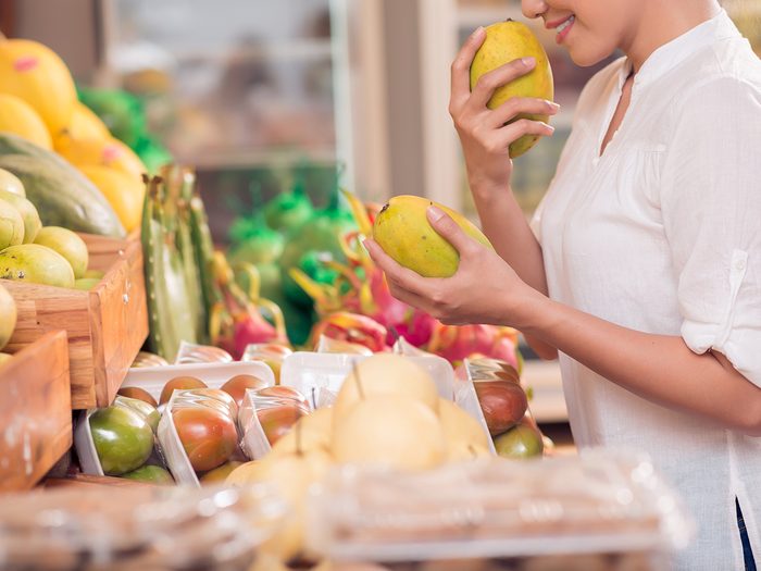 How to pick the best fresh fruit - woman sniffing mango