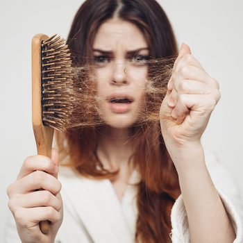 Why is my hair falling out - woman with hair brush