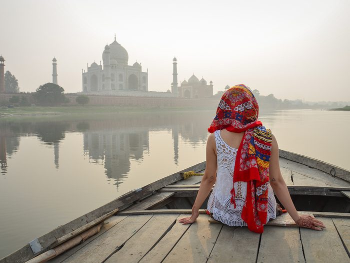 Woman on boat approaching Taj Mahal, India