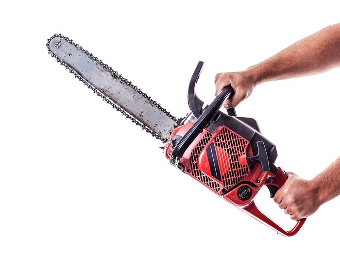 Arms holding chainsaw