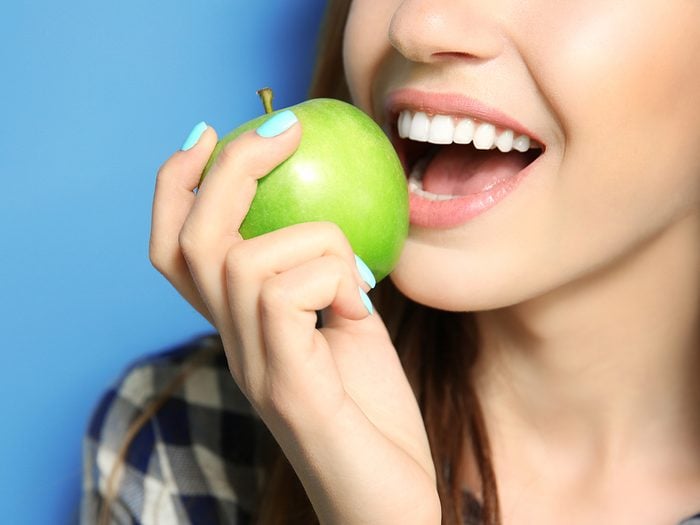 Benefits of apples - woman biting apple
