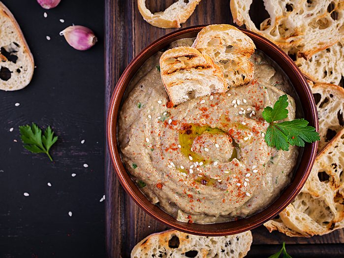 Baba ghanoush vegan hummus from eggplant with seasoning, parsley and toasts. Baba ganoush. Middle Eastern cuisine. Top view, overhead