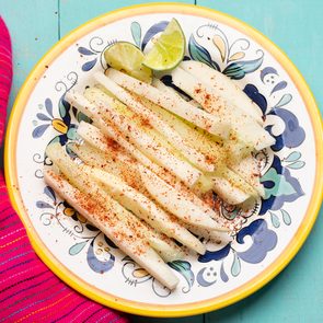 Best vegetables for weight loss - Traditional mexican jicama and cucumber cutted with chili powder on turquoise background
