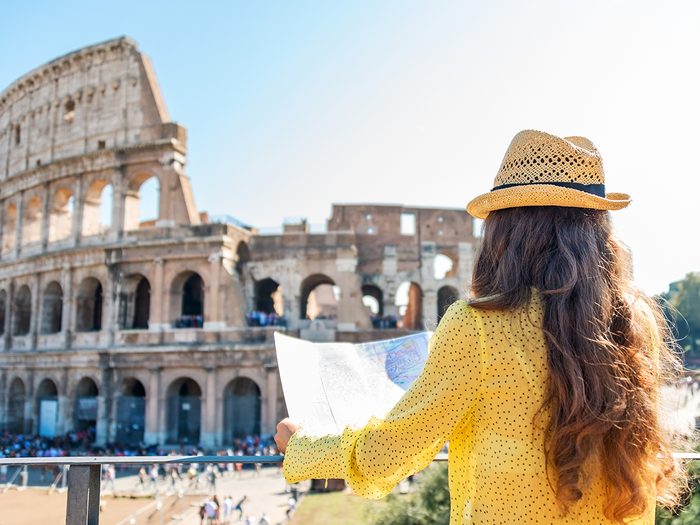 Budget travel tips - tourist holding map at Roman Coliseum