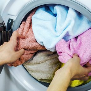 How to separate laundry - Woman gets clothes from the washing machine