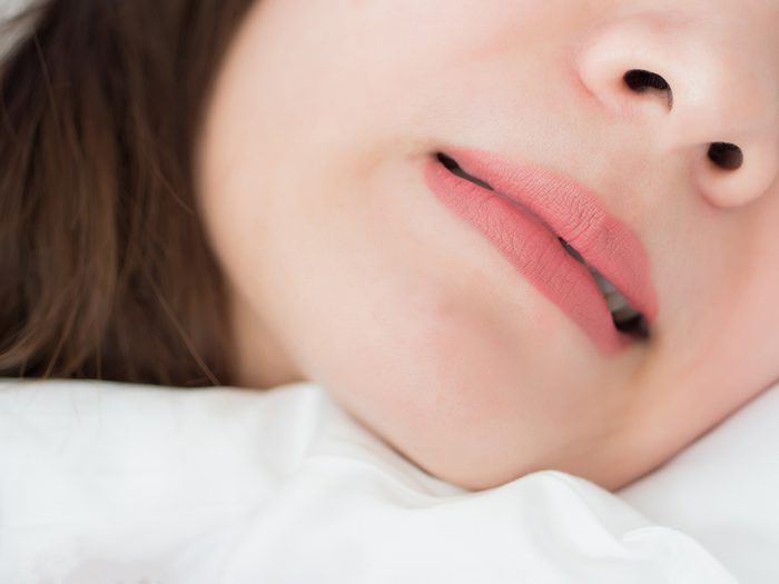 How to stop grinding your teeth at night - woman bruxing in sleep