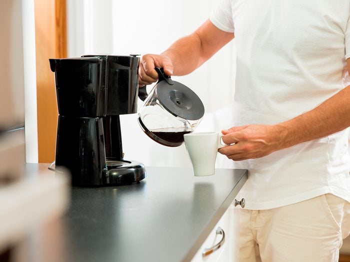 Man pouring coffee into mug