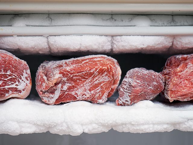 Things in your freezer you should toss - Big chunks of red beef lying on the freezer shelves with a big quantity of frozen ice and snow. This freezer hasn't been thawed in a long time.