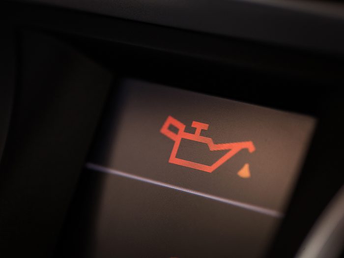 things you should never do to your car - Detail of the dashboard of a car, with the oil alert icon lit up