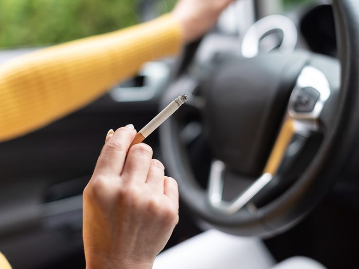 Woman smoking a cigarette while driving