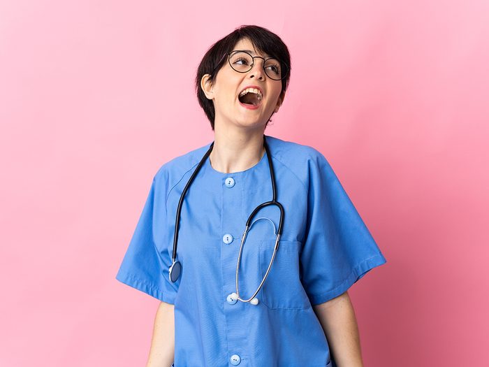 Young woman in scrubs laughing