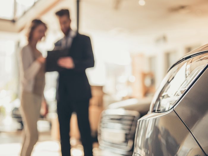 Car dealer tricks - woman buying car at dealership