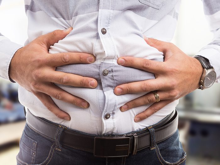 Man clutching bloated stomach