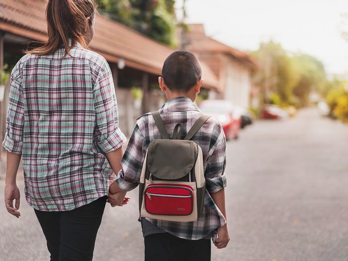 Rare genetic condition medical mystery - Mother or parent holding hand son or pupil with backpack go to school, Back to school concept, Selective focus.