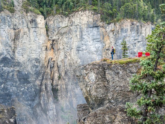 Unesco World Heritage Sites Canada - Visitor at the Red Chairs at Nlcho (Virginia Falls). Nahanni National Park Reserve.