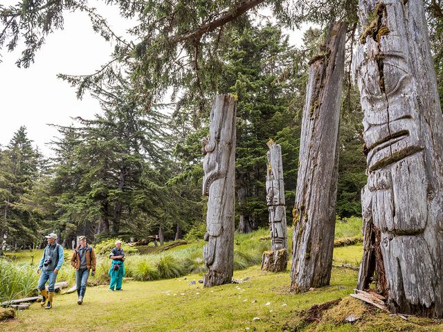 Unesco World Heritage Sites Canada - Ancient poles stand after hundreds of years, rimming the Haida village of SGung Gwaay Llnagaay. Gwaii Haanas National Park Reserve and Haida Heritage Site