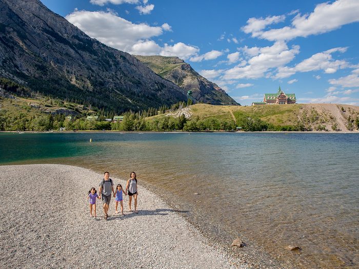 Unesco World Heritage Sites Canada - A young family walking along the beach at Emerald Bay, Waterton Lakes National Park
