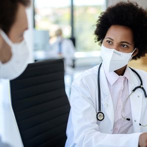 When to see your doctor - doctor communicating with a patient while wearing protective face mask during medical appointment