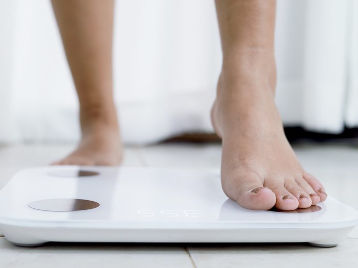 When to see your doctor - feet standing on electronic scales for weight control