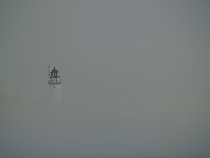 Lighthouse emerging from fog