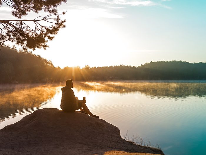 Moment of calm - person meditating at lake