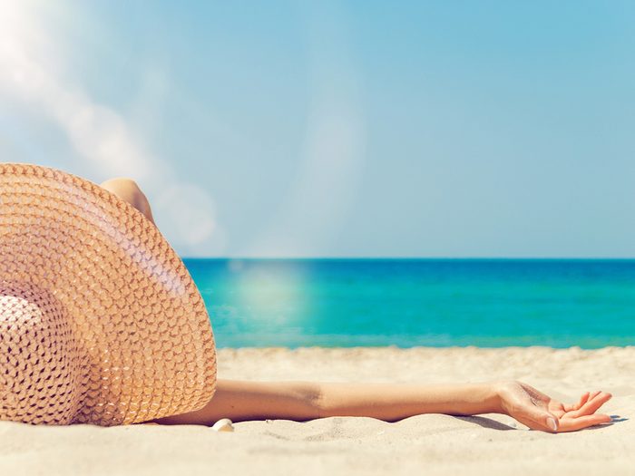 Bad habits to quit - woman tanning on beach