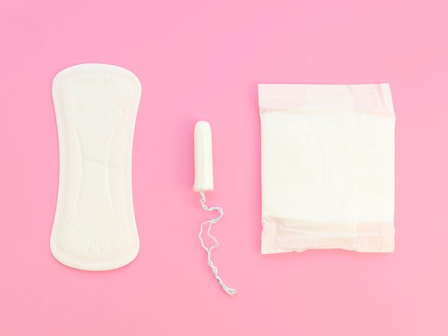 Pink flat lay compostion feminine pads and tampons on a pastel pink background. Menstrual cycle idea
