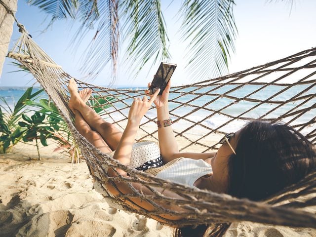 Woman using phone in hammock