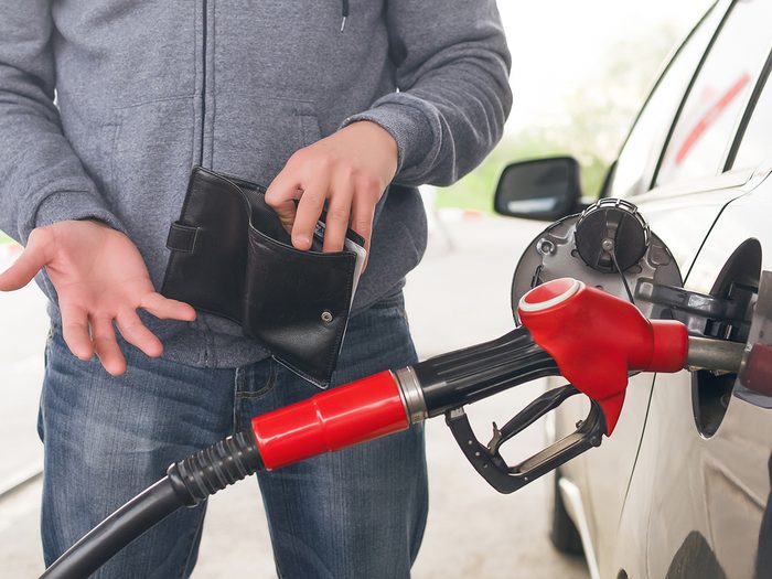 Cheapest gas station near me - man pumping gas empty wallet
