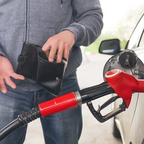Cheapest gas station near me - man pumping gas empty wallet