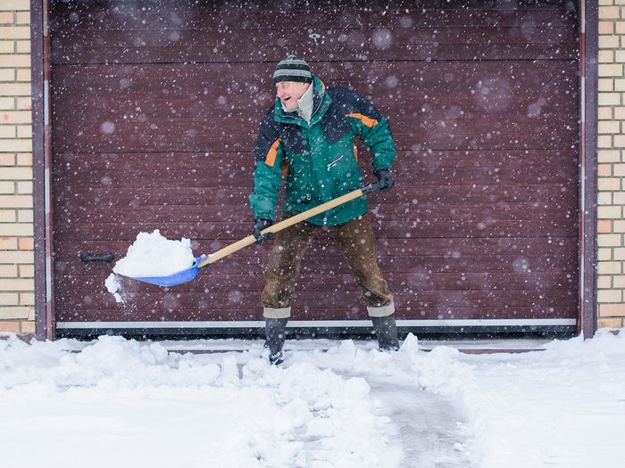 Man shovelling snow from driveway
