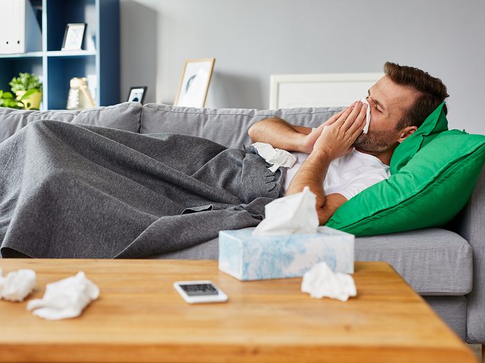 Man sick with cold lying on couch