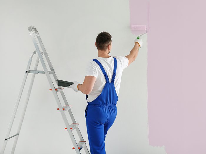 Painter painting wall light pink