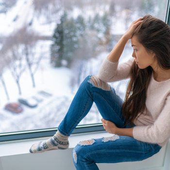 Signs of seasonal affective disorder - depressed woman in winter