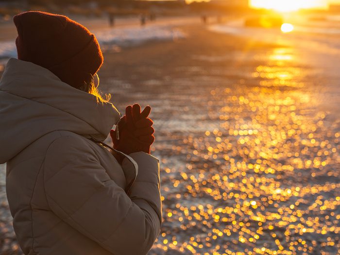 Vitamin D deficiency symptoms - woman watching winter sunset