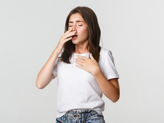 Young woman sneezing
