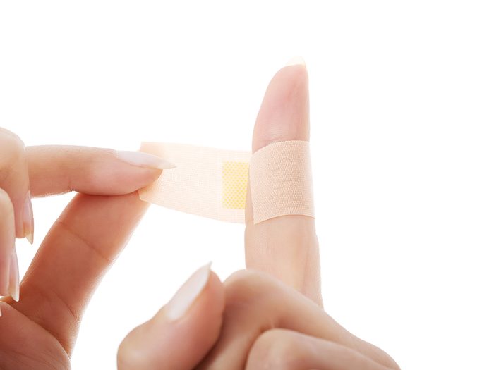 Applying adhesive bandage to finger