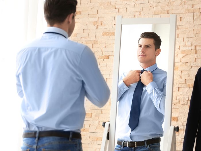 Man dressing in front of mirror