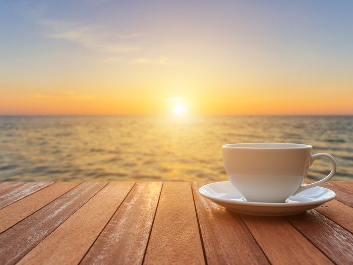Coffee roaster - coffee cup at sunrise beach