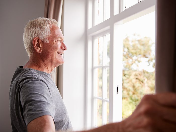 Risk factors for osteoporosis - senior man opening window