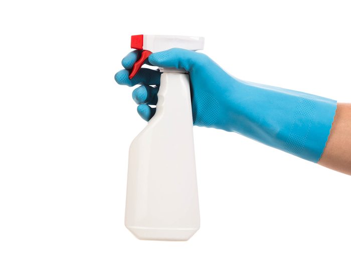 Holding spray bottle in rubber gloves