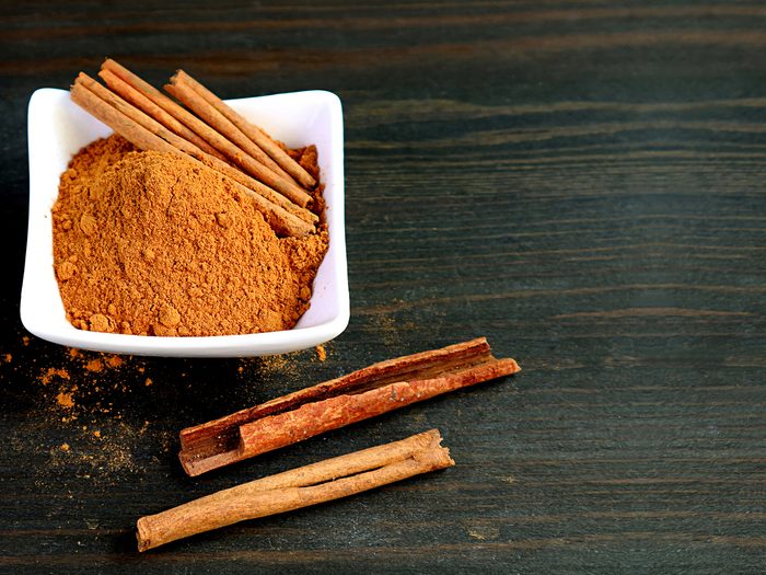 Coffee sweetener - a bowl of cinnamon next to cinnamon sticks