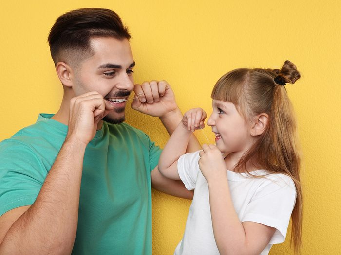 Father and daughter flossing