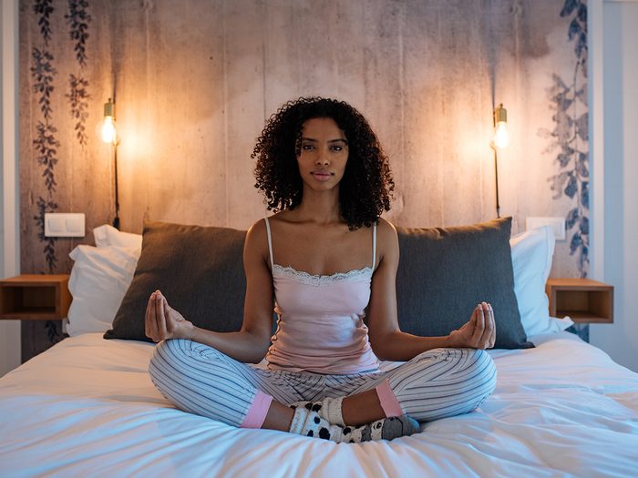 Natural sleep aids that work - woman meditating in bed