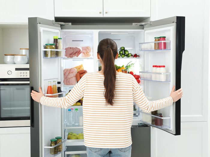 Best temperature for fridge - woman opening refrigerator door
